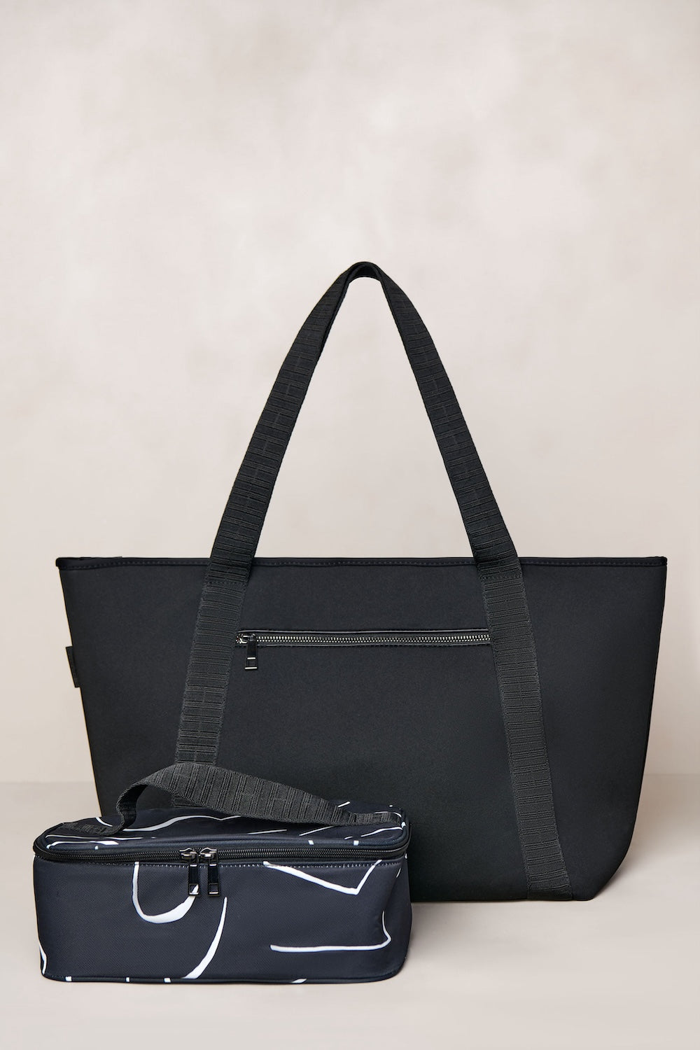 Black tote bag with a smaller black pouch on a light beige background