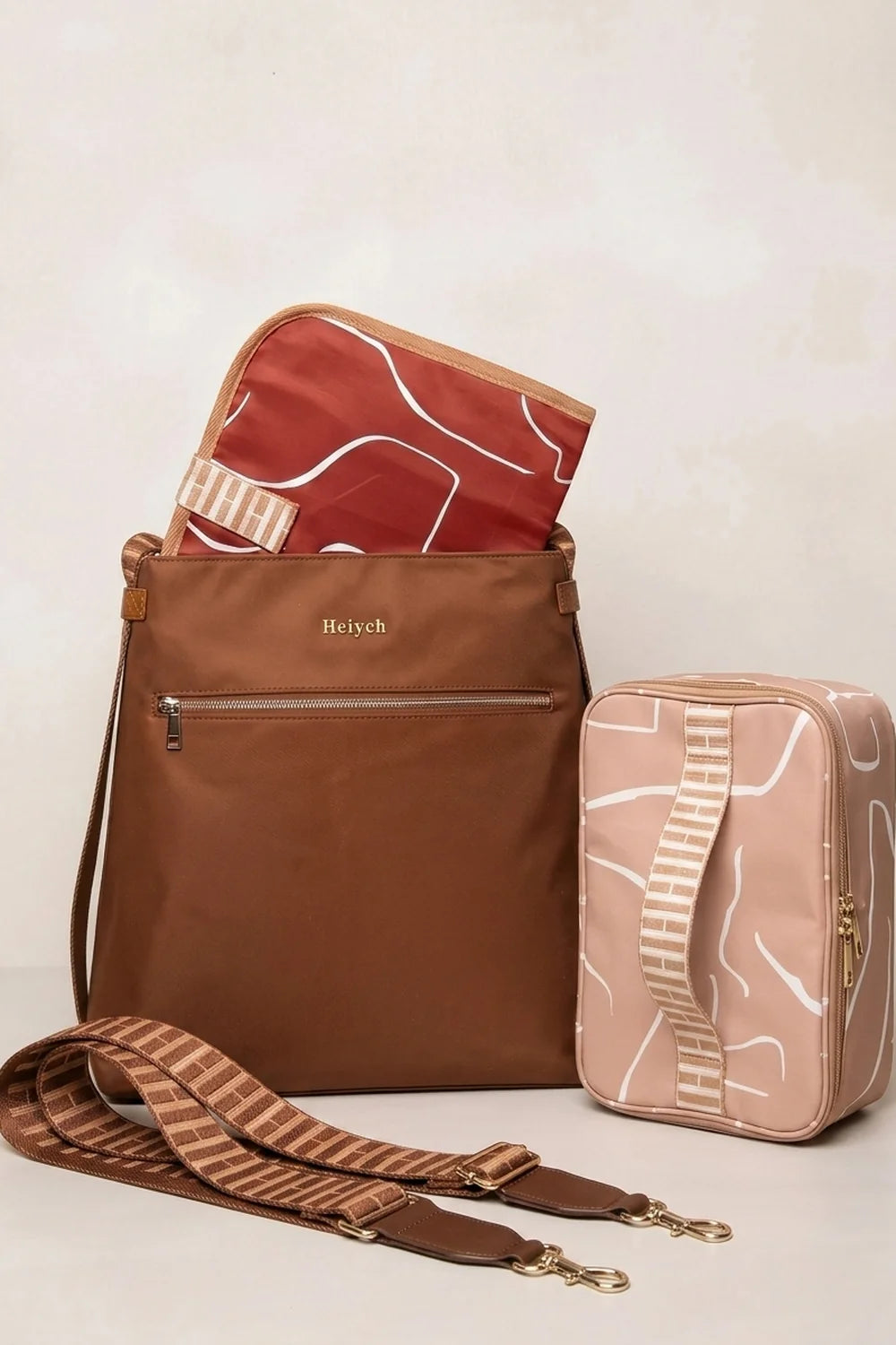 A cognac tan nylon tote backpack bag with a matching patterned red liner and a coordinating light pink pouch, displayed on a light beige background.
