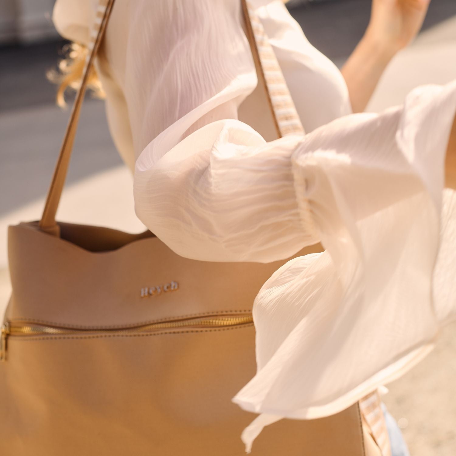 Tan neoprene shoulder bag with gold zipper and Heych logo