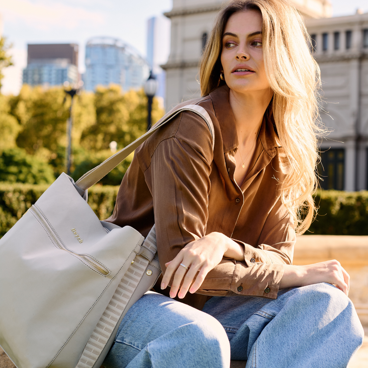 Woman carrying tote bag over her shoulder outdoors