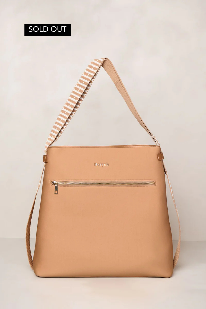 Tan terracotta handbag with a striped strap on a light beige background