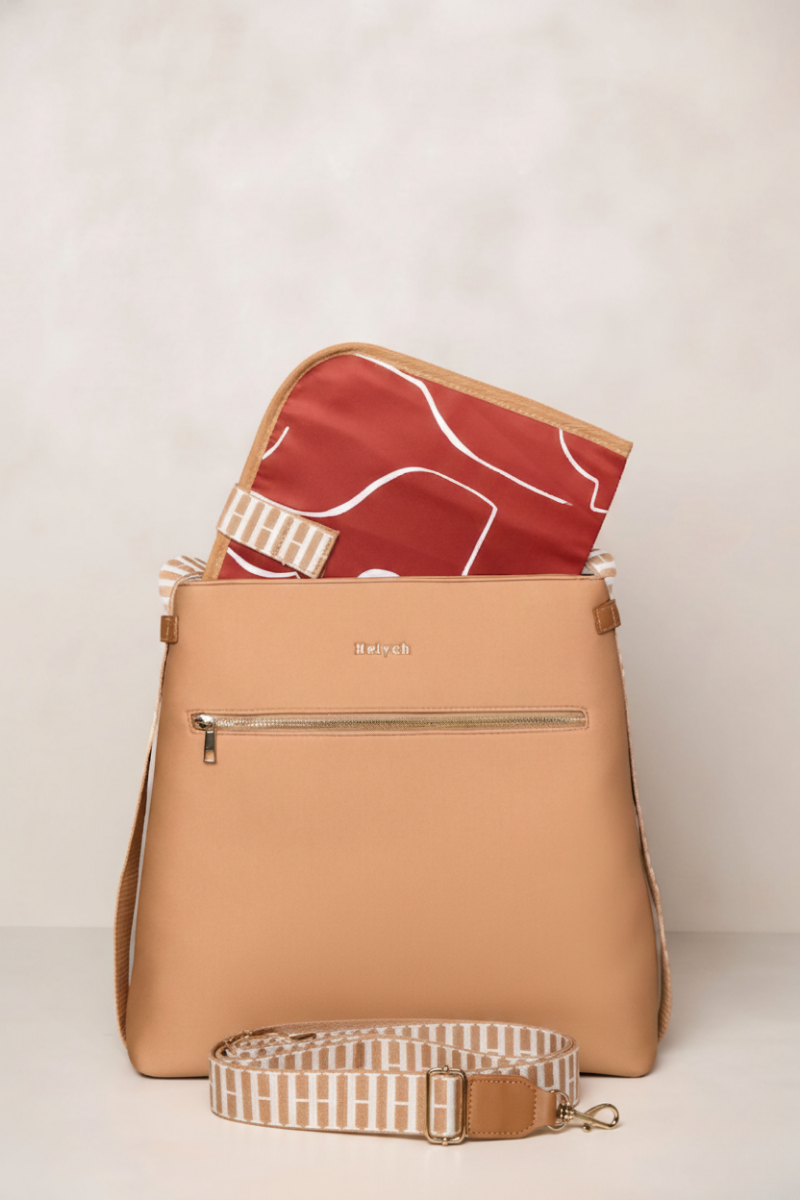 Tan backpack with a rust interior and crossbody strap on a light background