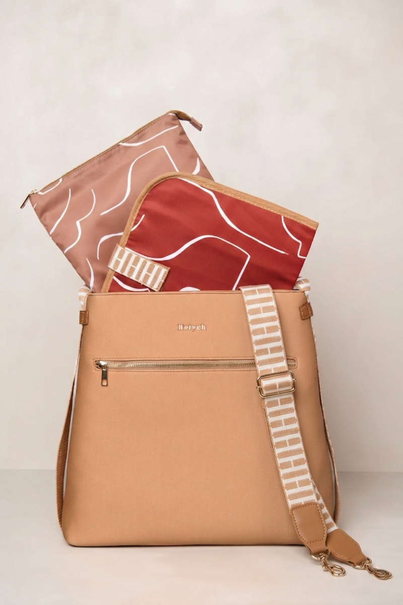 Tan backpack with a strap and two patterned pouches on a white background