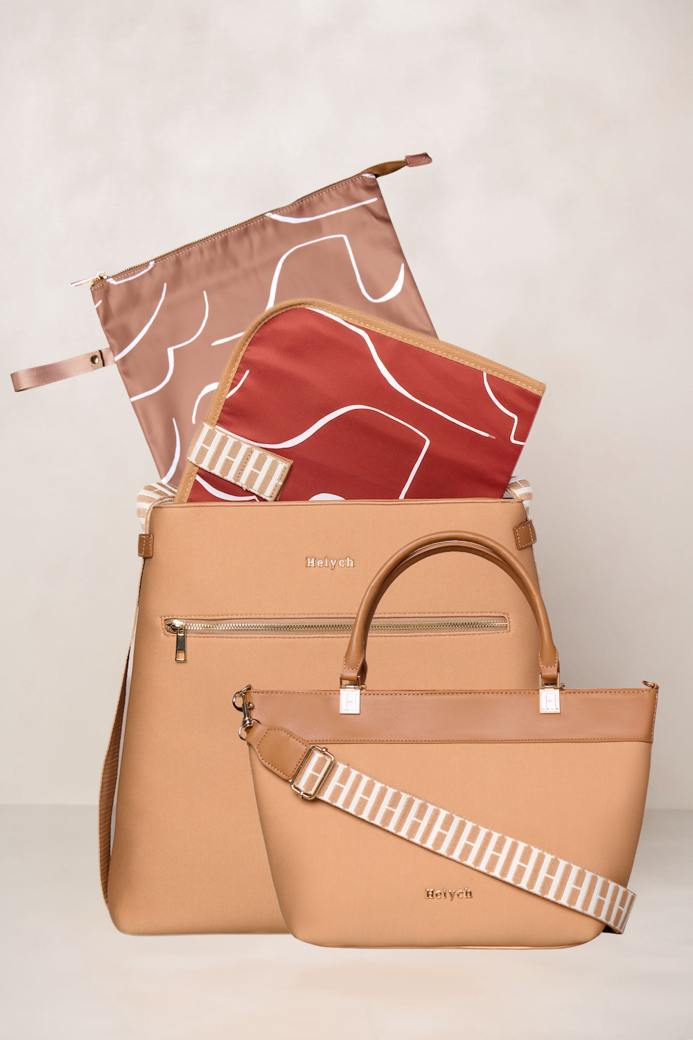 Tan handbag with a strap and two patterned pouches on a light background