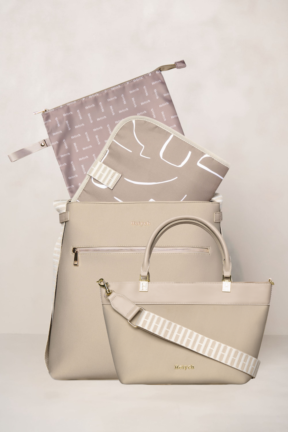 Beige taupe handbag with a smaller pouch and a patterned pouch on a light background