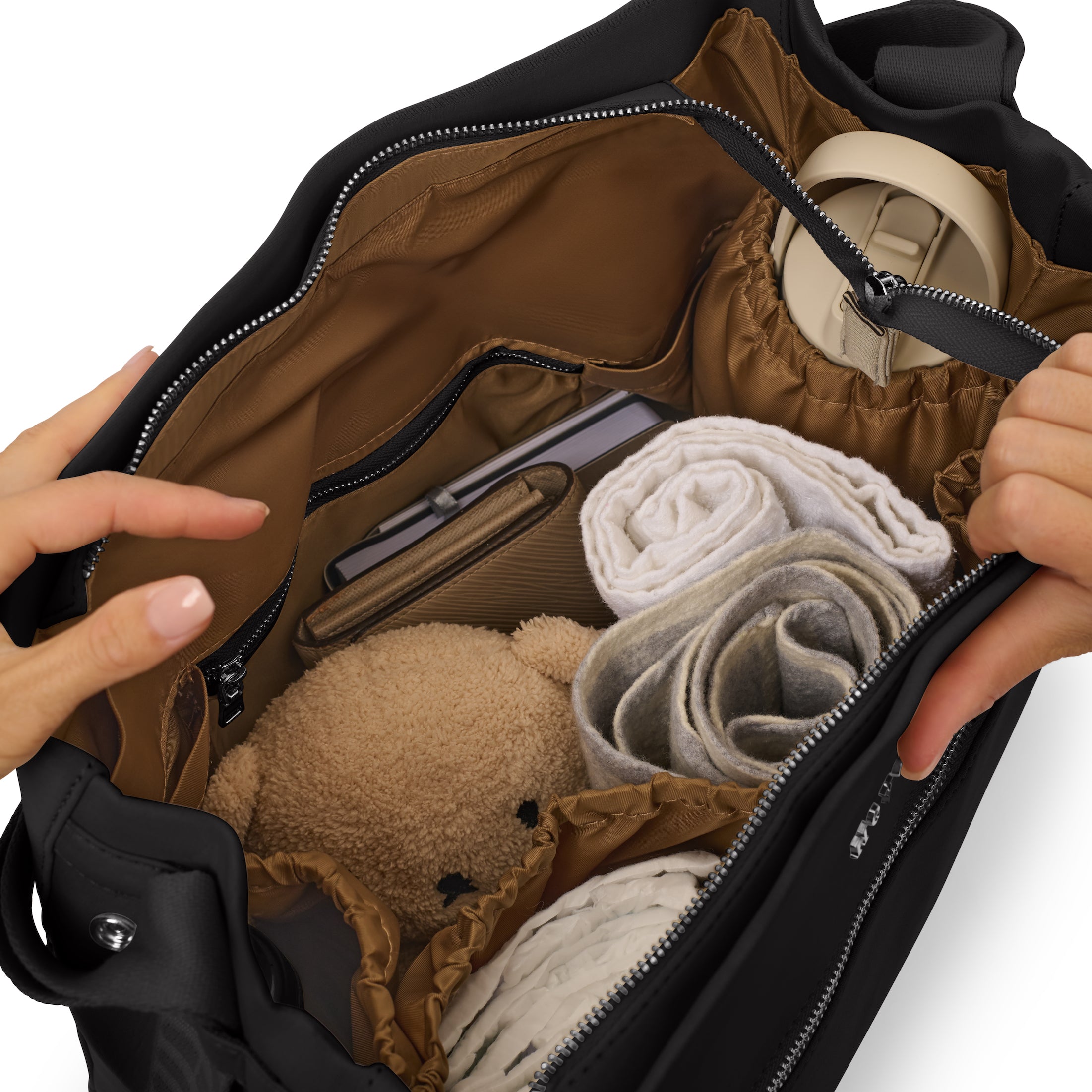 Open baby bag showing neatly organised compartments with diapers, a drink bottle, change of clothes, and a small toy.