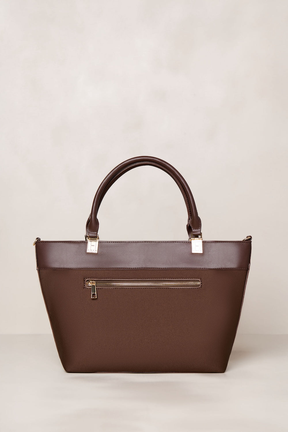 Chocolate Brown handbag with a gold zipper on a light gray background