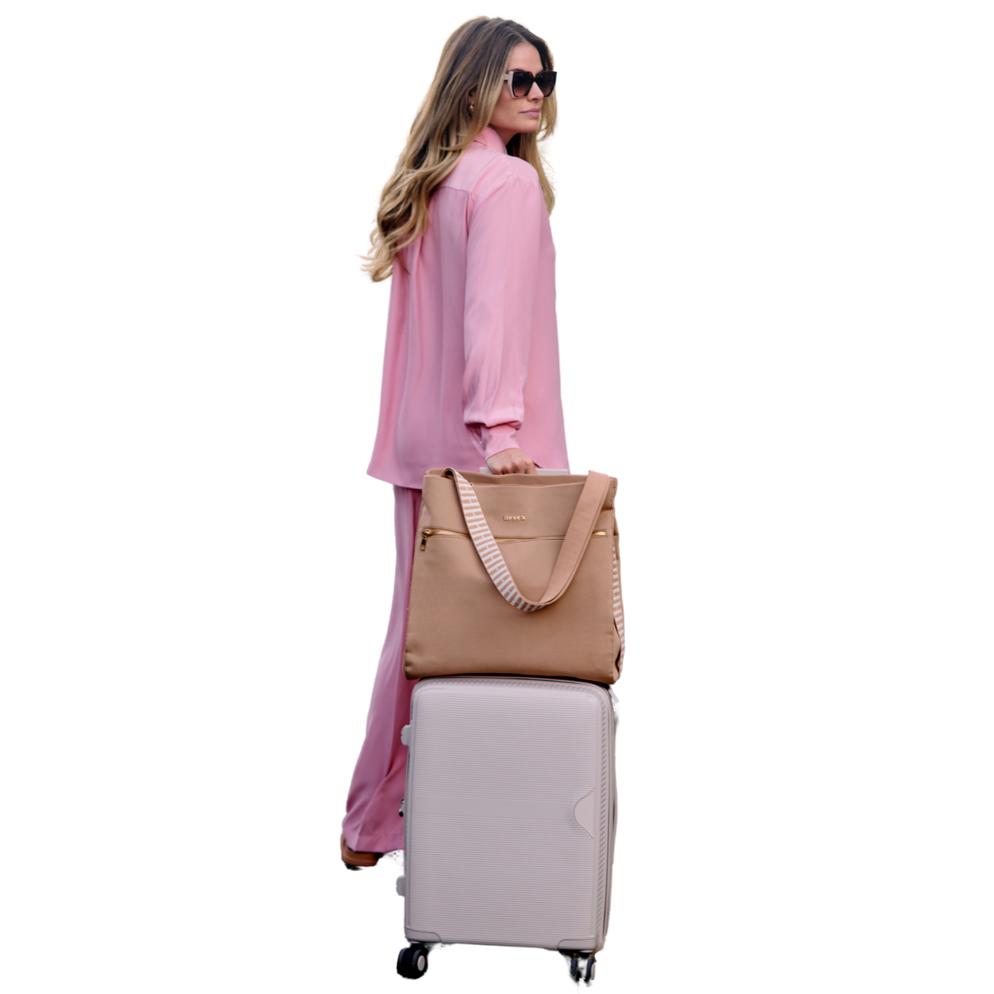 Woman with tan neoprene tote bag over carry on suitcase showing how bag luggage pass through band works.