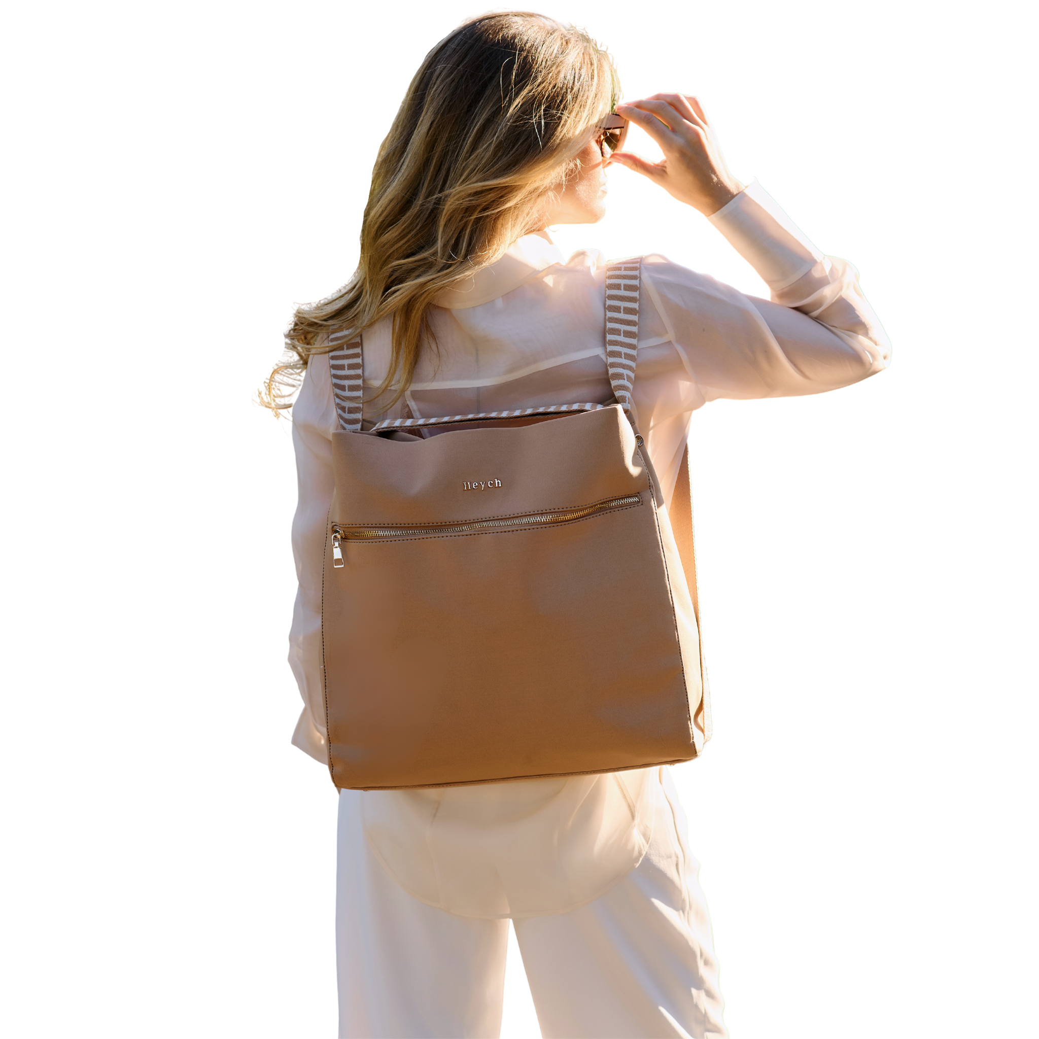 Tan neoprene tote bag converted into a backpack worn by a woman.