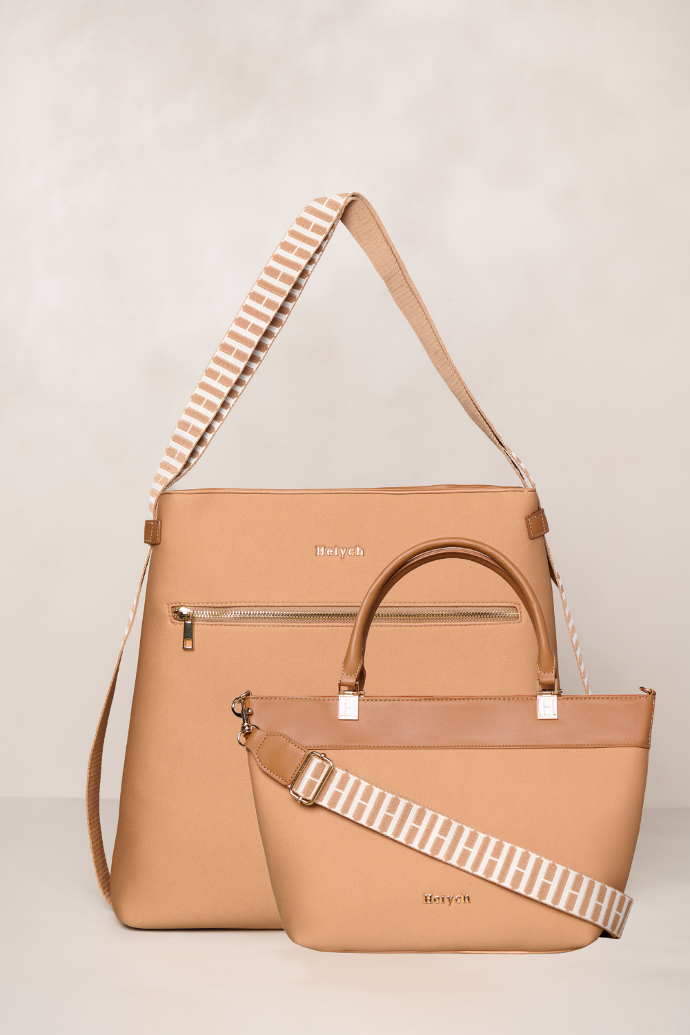 Tan handbag with a striped strap on a light beige background