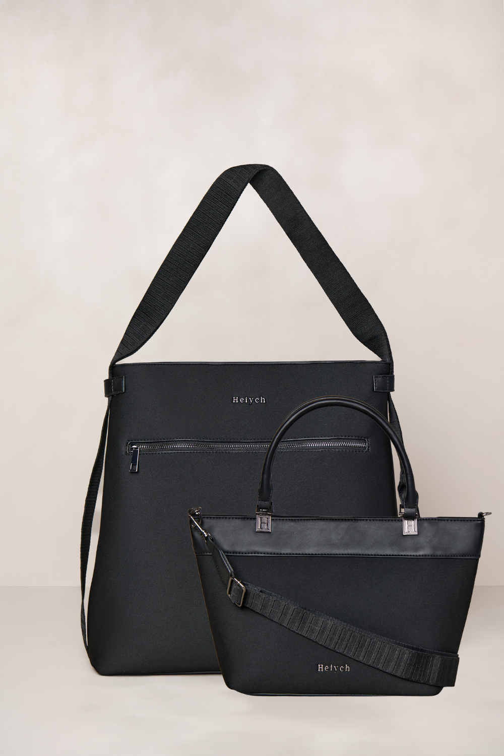 Two black handbags with visible brand name on a light background